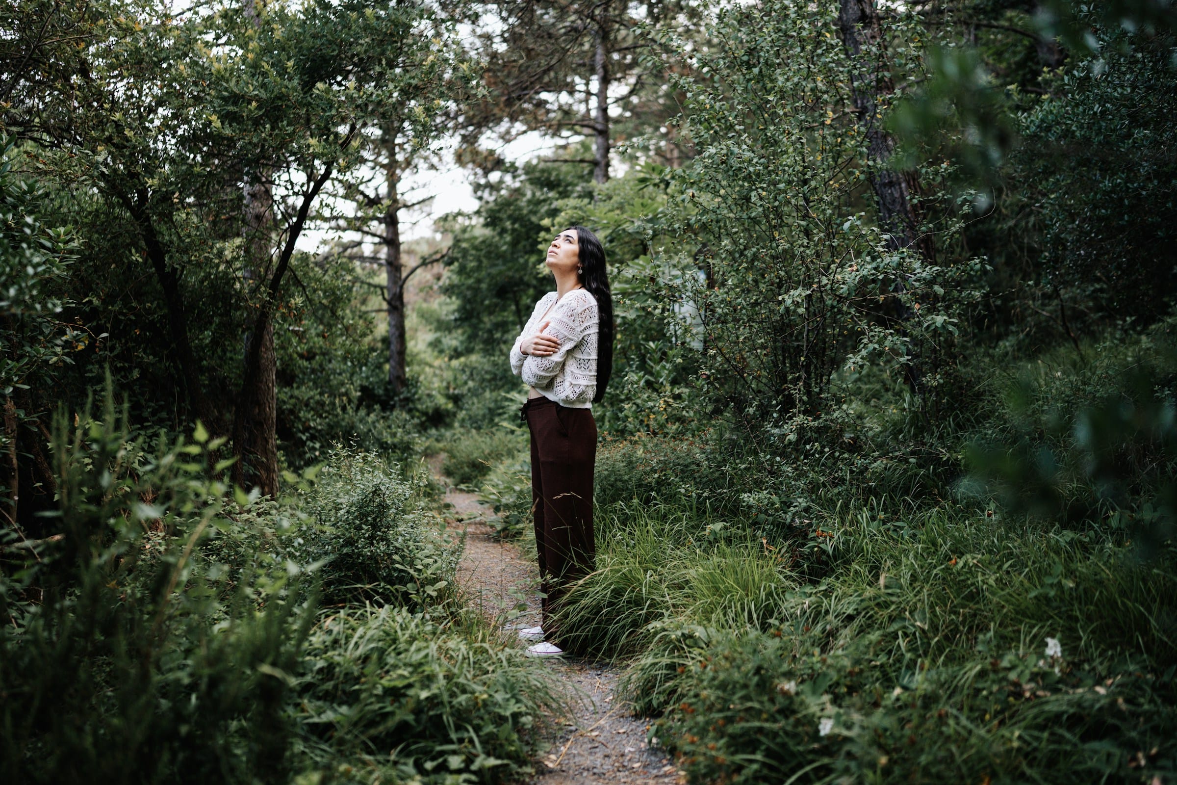 A woman standing in a forest representing anticipatory grief.