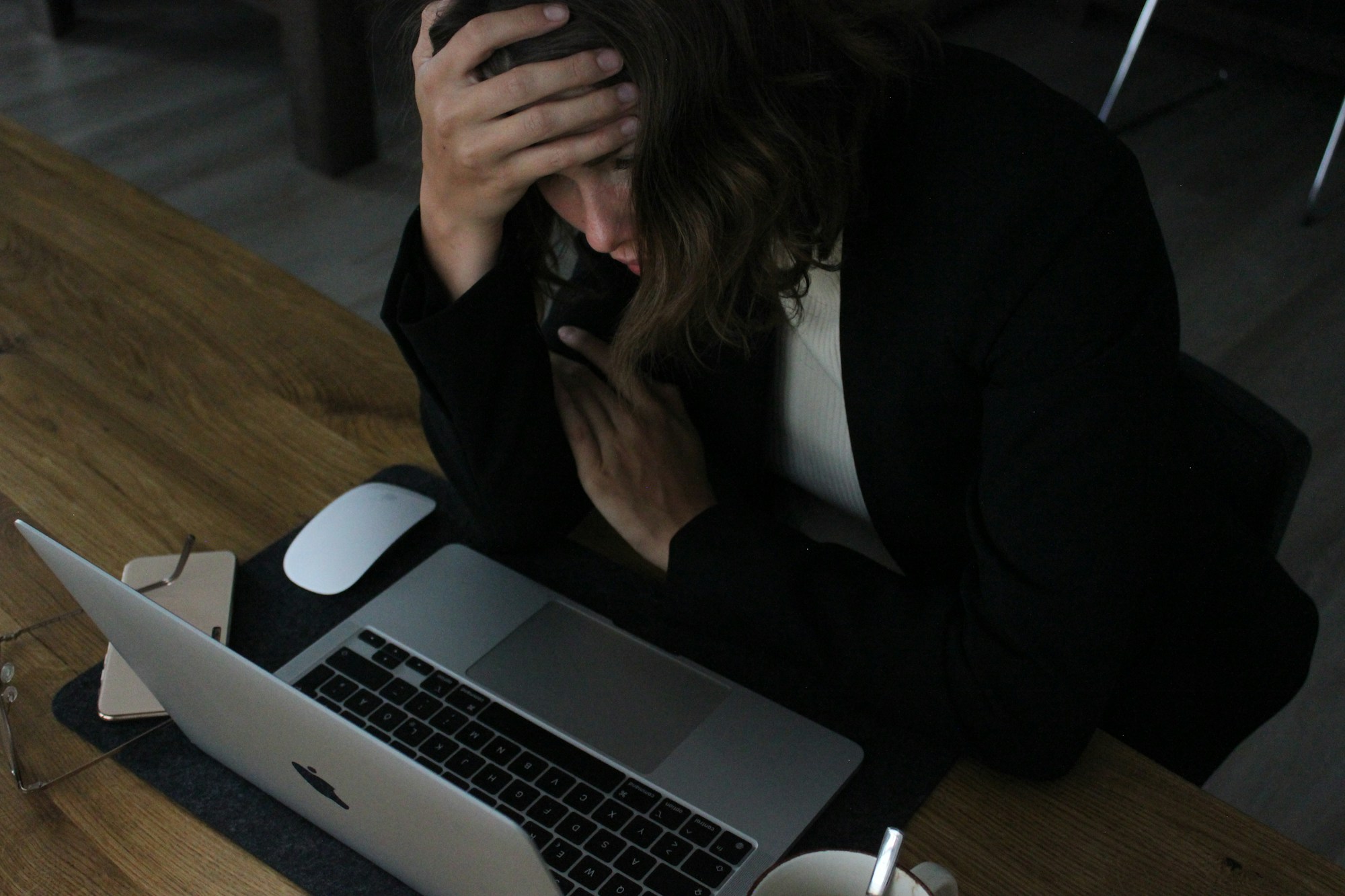 Woman sitting at her computer with her head in her hands, thinking about her career dissatisfaction.