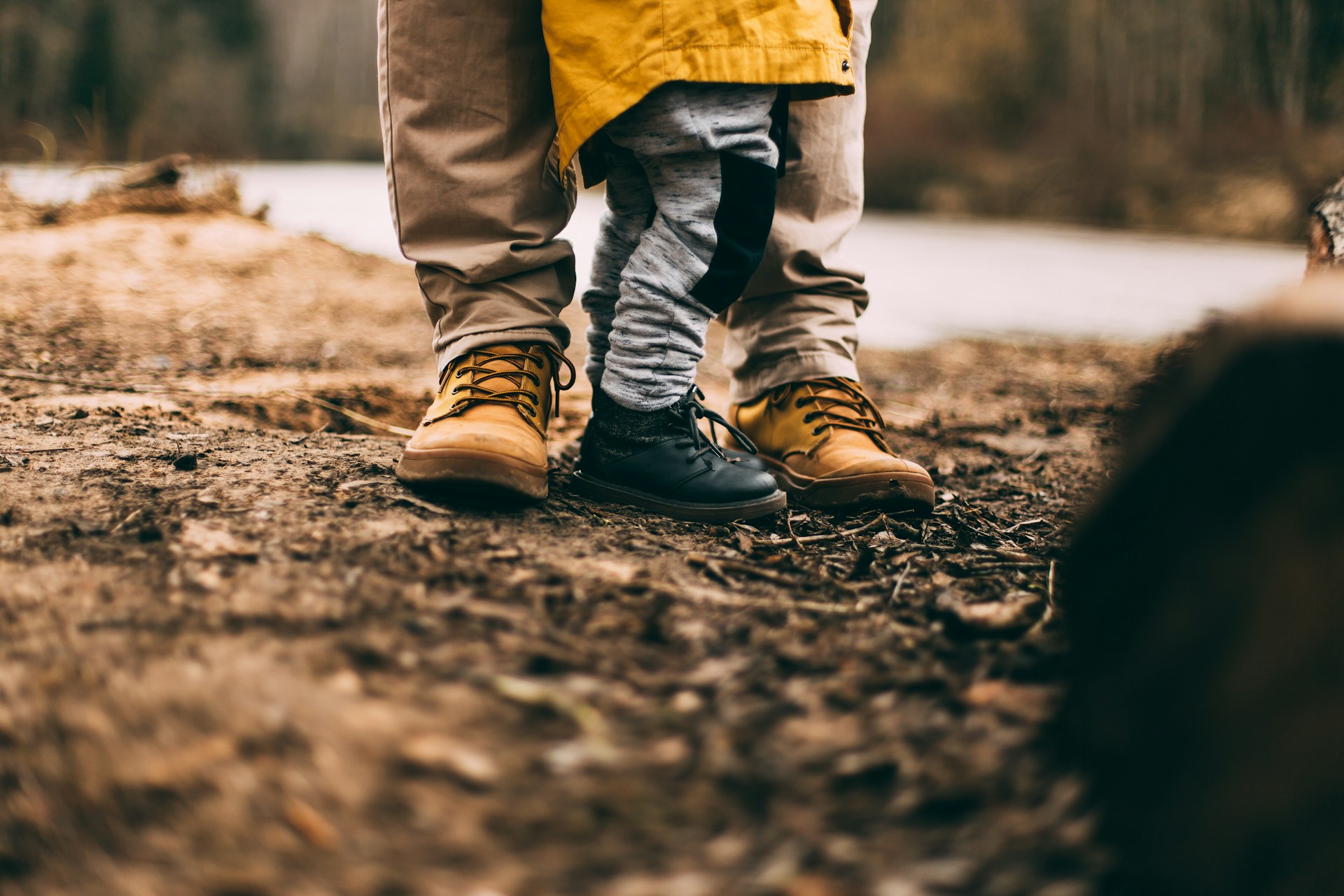 Parent and child's feet outside in the mud, while the adult is thinking about co-parenting after divorce.