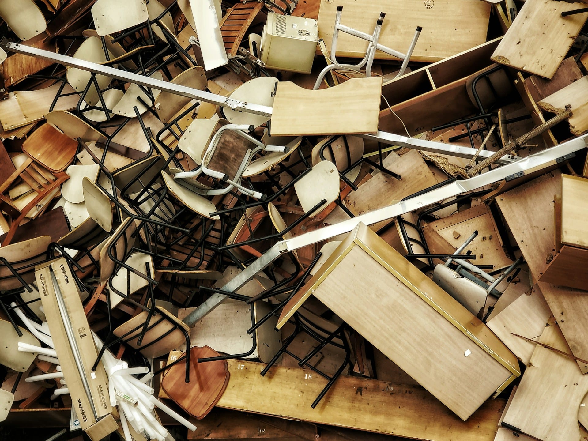 A chaotic pile of chairs and desks representing disorder, overwhelm, and the mental clutter often experienced before an ADHD diagnosis.