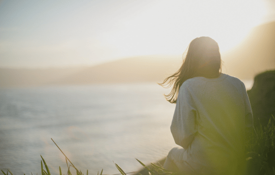 woman sitting on the beach at sunset