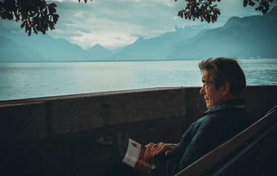 a man reading a book on a bench