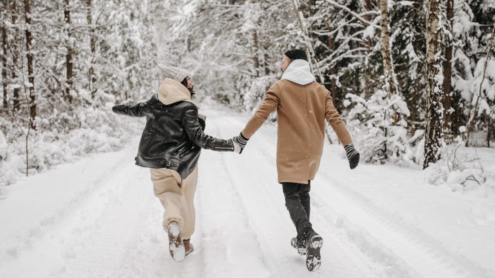 Couple playing in a snowy forest in Seattle to cope with holiday grief