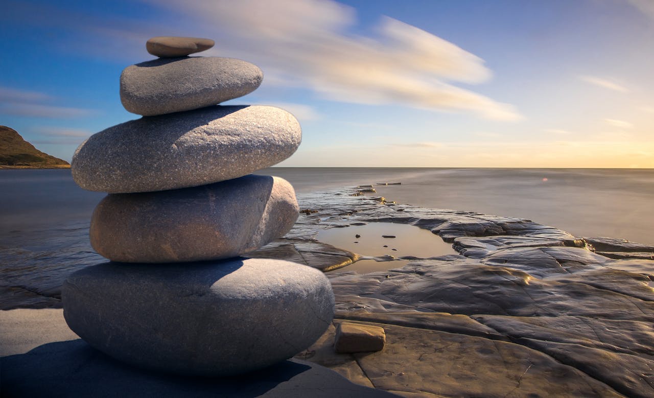 Stacked stones on a beach representing spiritual therapy session in Seattle.