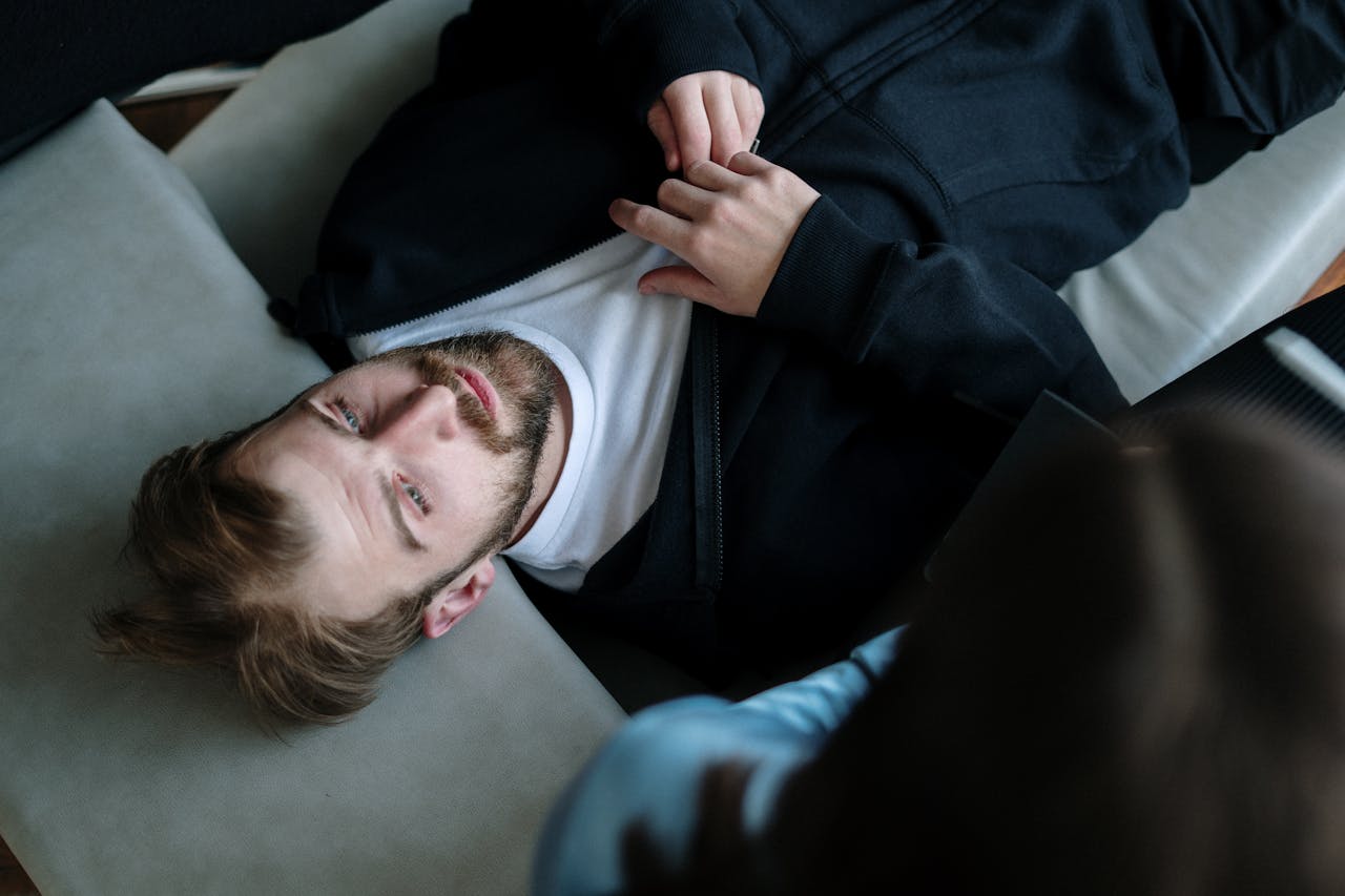 Man in Black Jacket Lying on White Pillow thinking about Disconnection