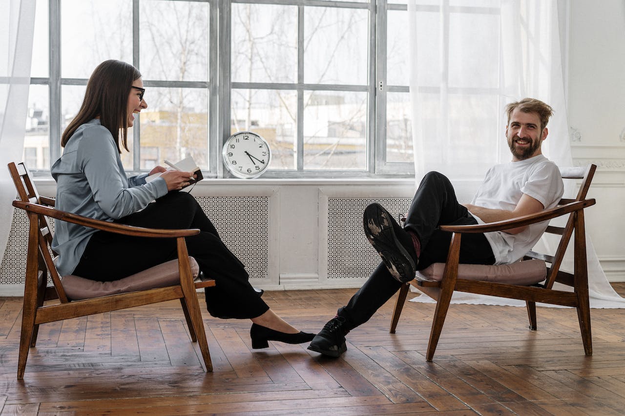 2 People Sitting on Brown Wooden Chair talking about Healing From Psychological Trauma