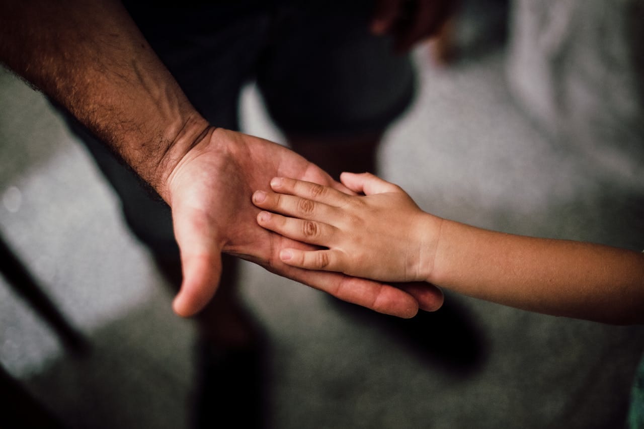 Father and Child's Hands Together showing the Impact of Religious Abuse on Parents