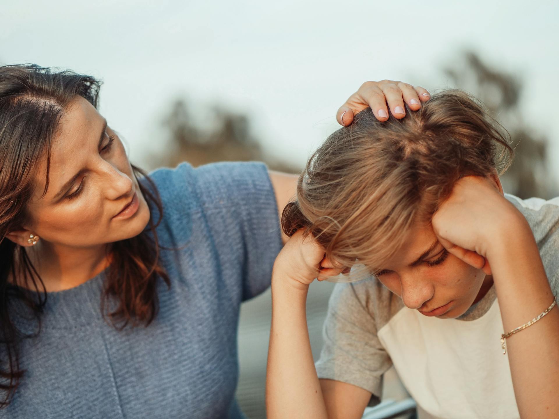 Woman in Blue Shirt Talking to a Young Boy in White Shirt about the Link Between Childhood Trauma and Autoimmune Disease