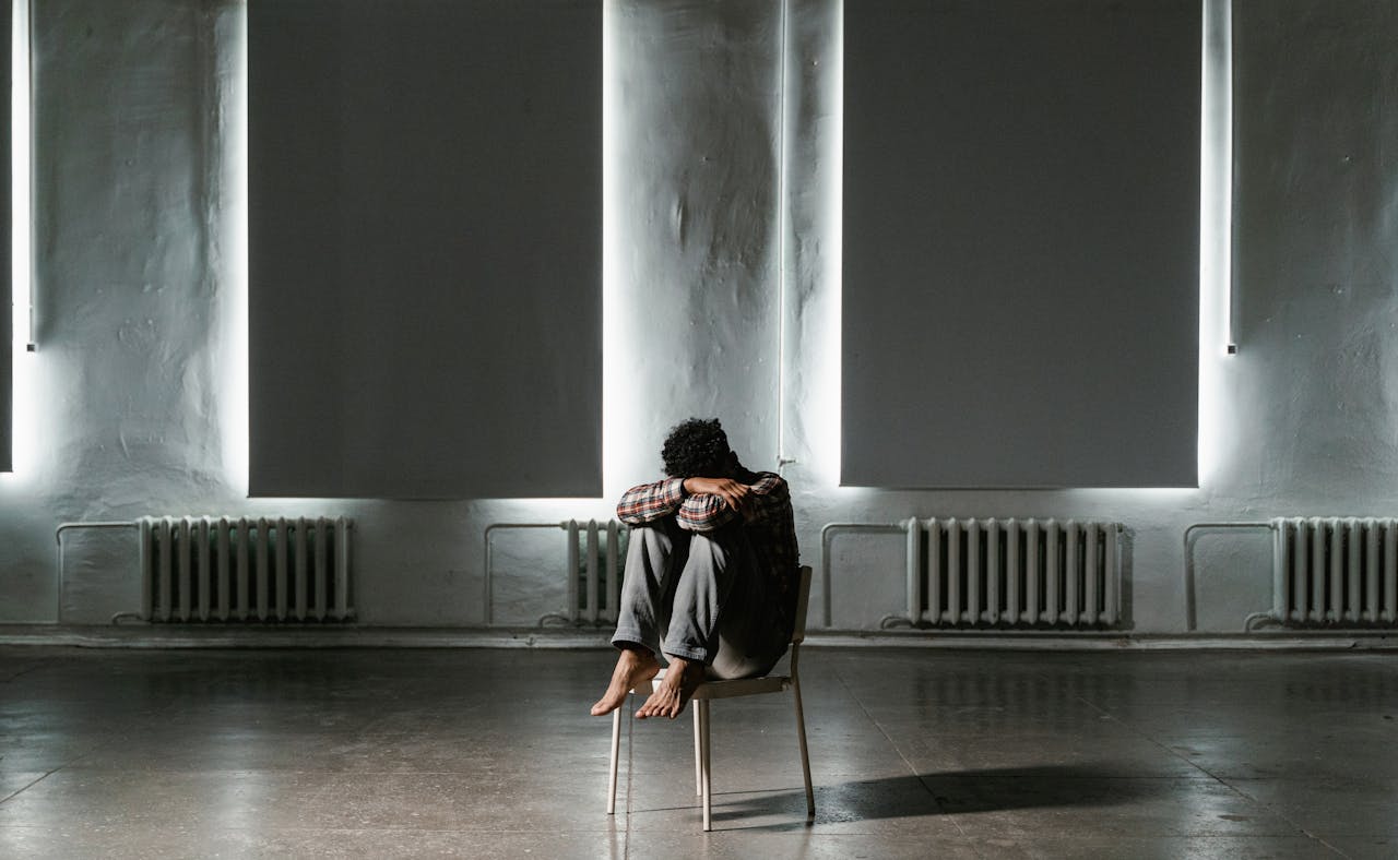 Person sitting on a chair inside an empty room thinking about phobia therapy in Seattle.