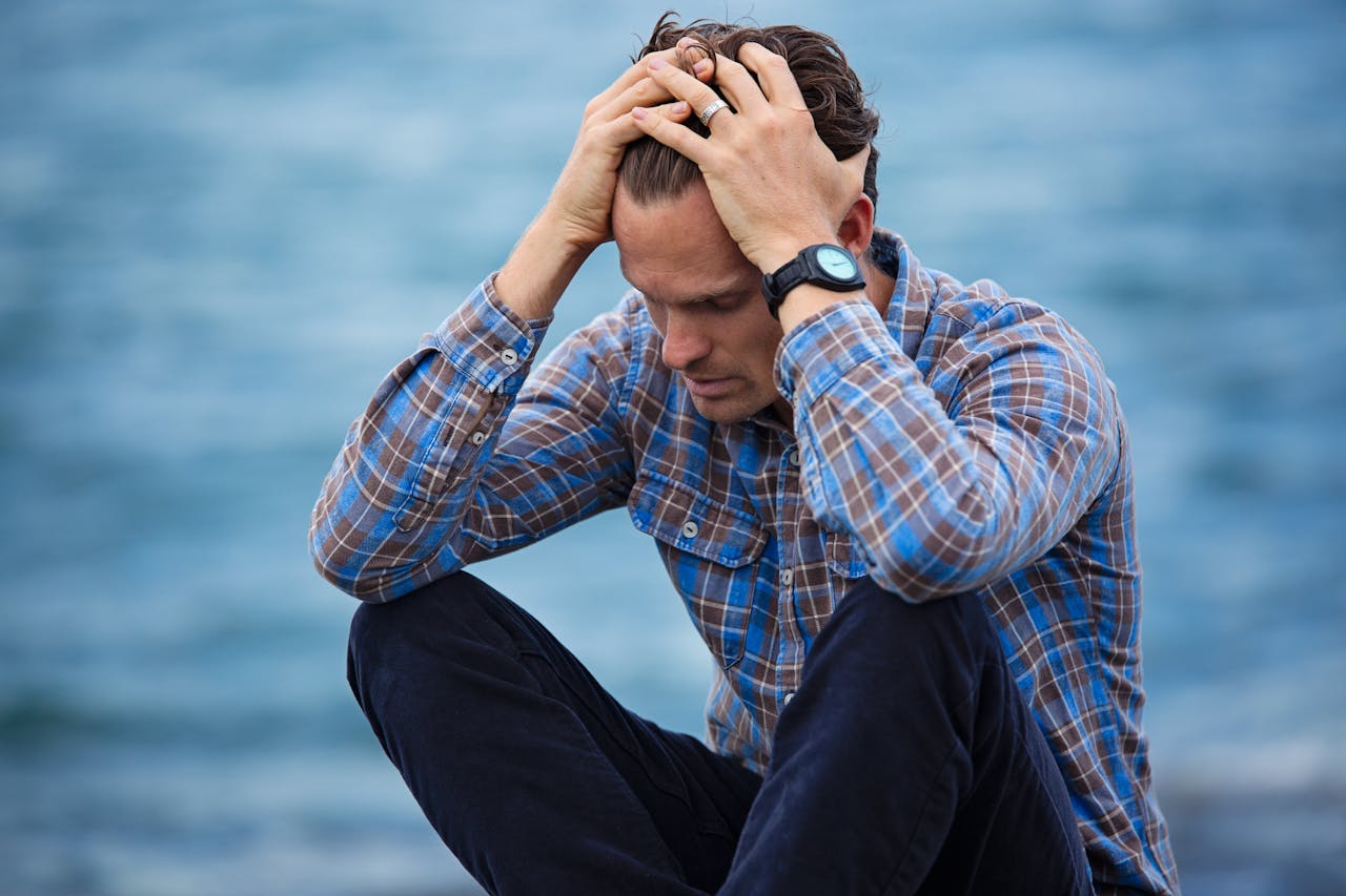 Man in Blue and Brown Plaid Dress Shirt Touching His Hair thinking about Therapy in Seattle