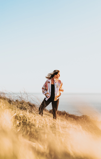 a woman standing on a cliff edge