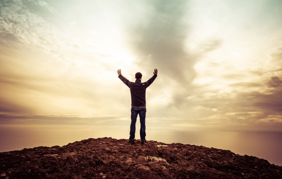 man standing on top of a mountain