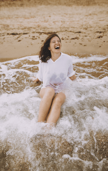 portrait of a young woman laughing on the beach
