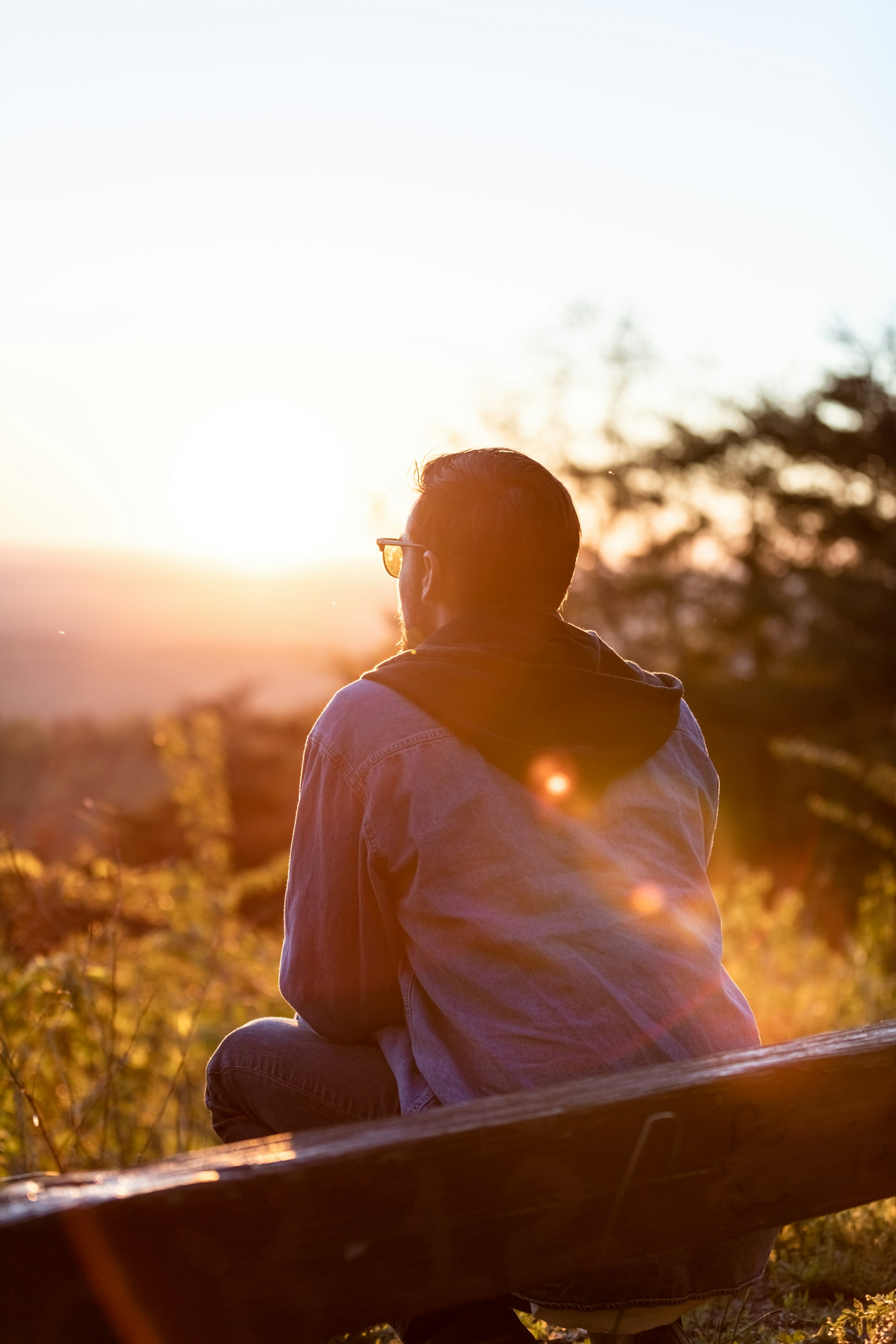 Man sitting on a bench overlooking the mountains outside thinking about attending therapy for intrusive thoughts in Seattle.