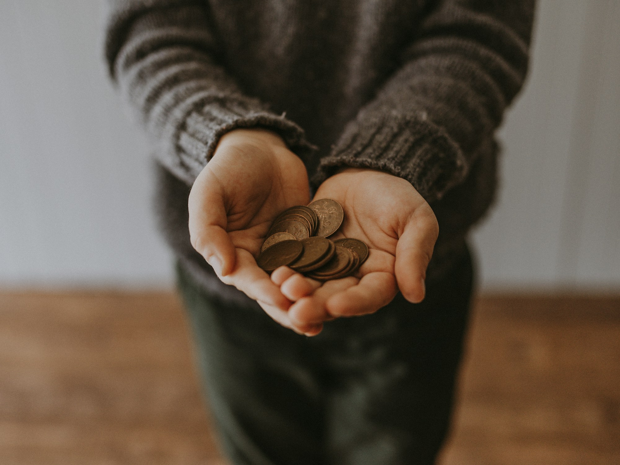 Close-up of a child holding coins in their hands after a discussion about money and mental health.