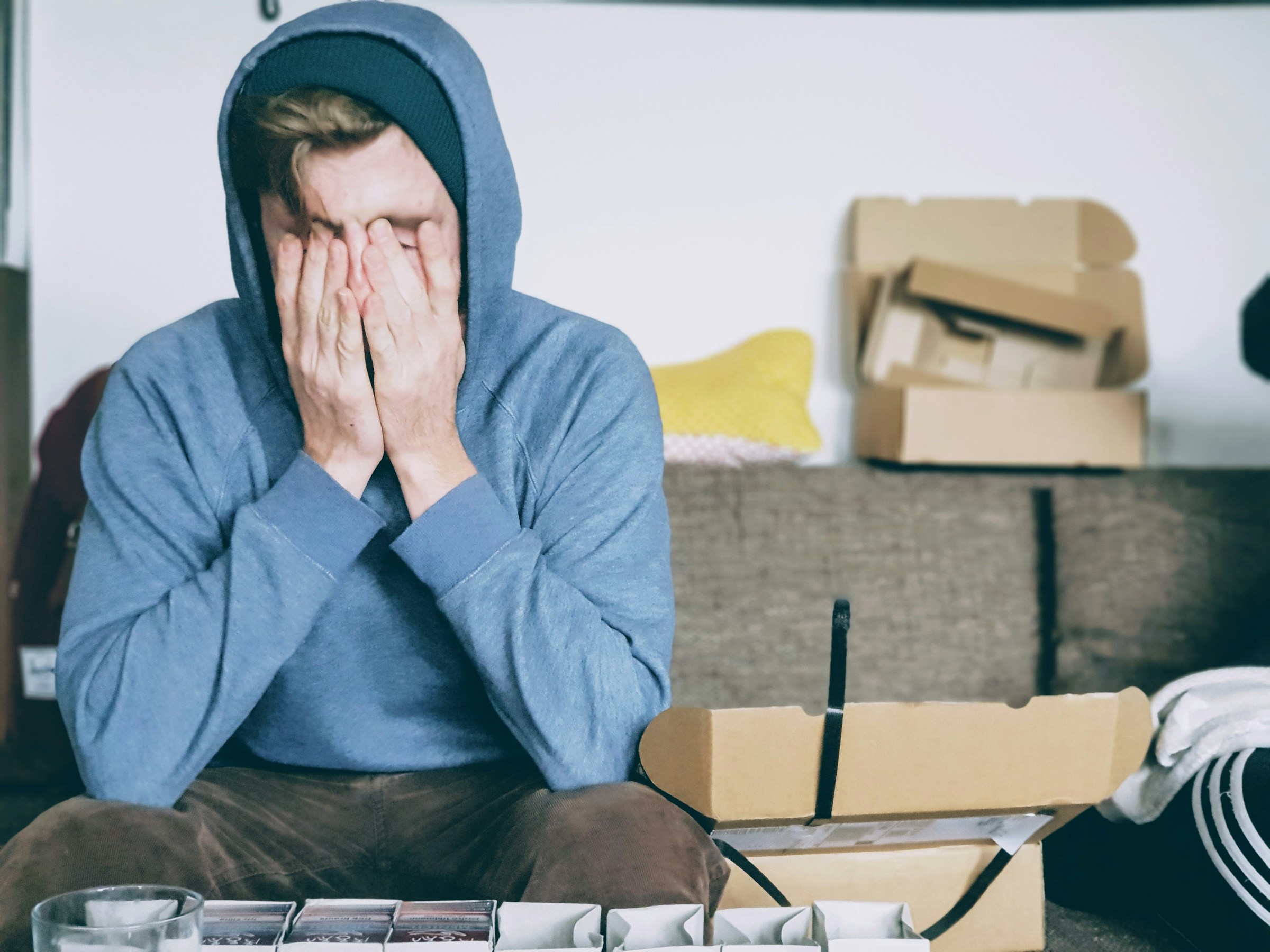 A man sitting on a couch with his head in his hands thinking about how his partner has covert narcissism.