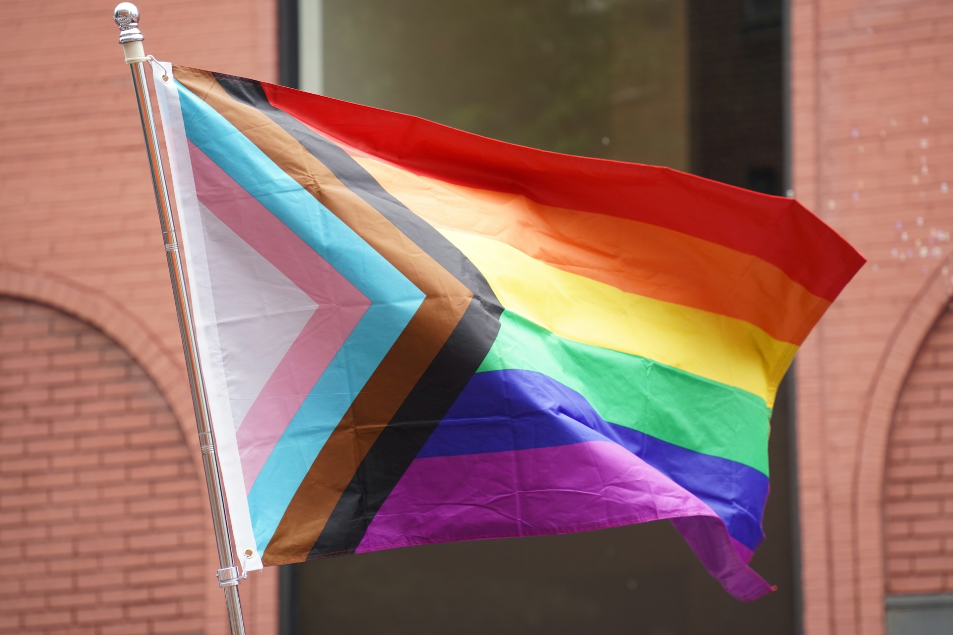 Inclusive pride flag blowing in the wind, representative of a conversation on LGBTQ mental health statistics.