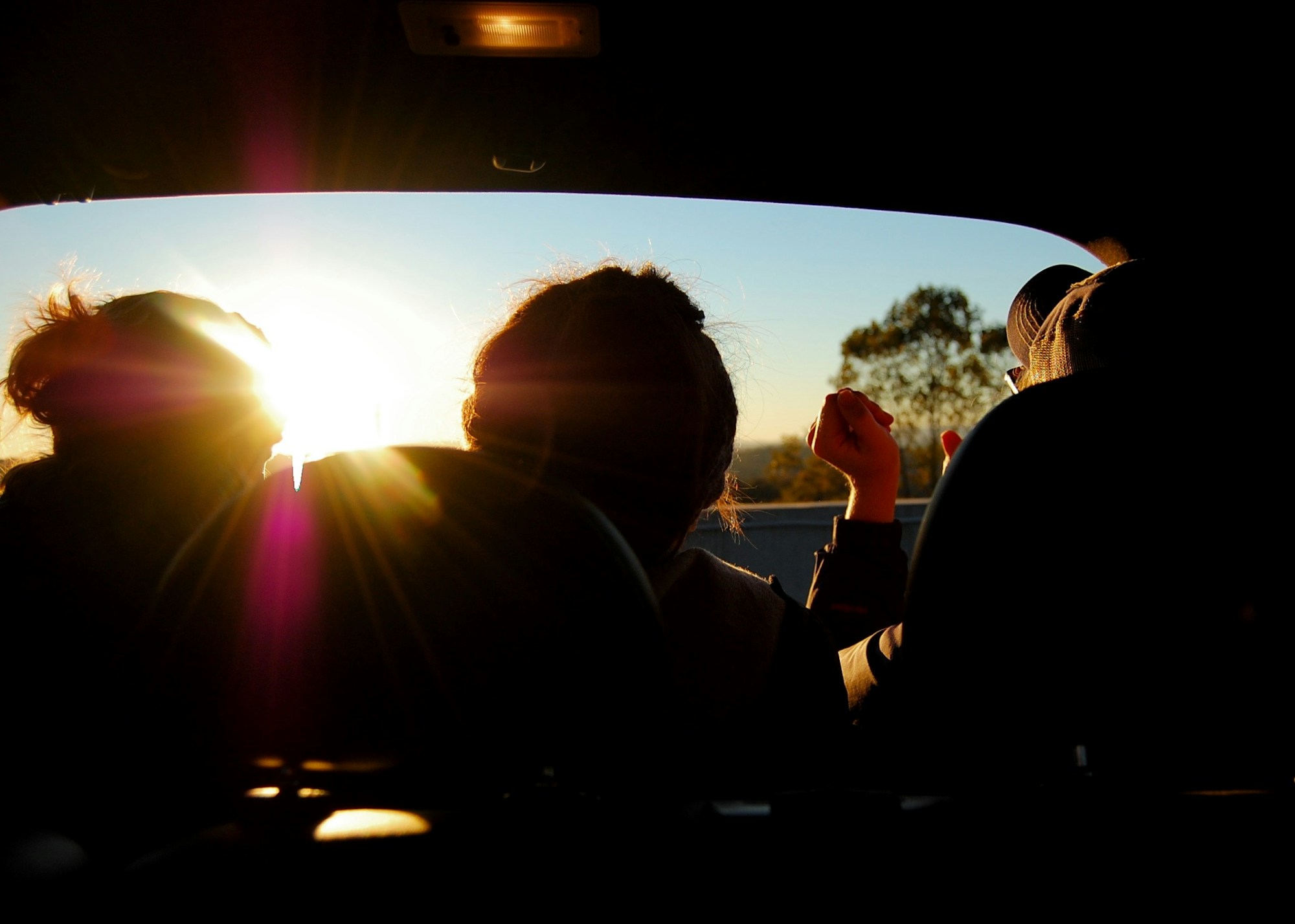 Silhouette of three friends riding in a car together after group therapy for hyper-independence and trauma.